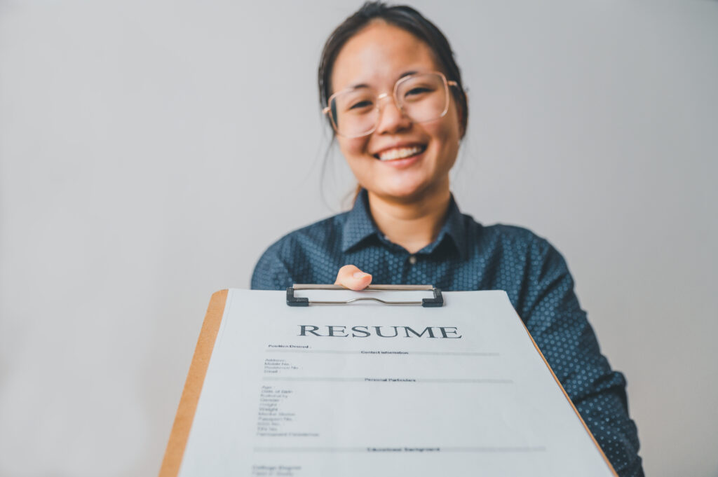 Job seeker holding a completed resume, symbolizing how to build a resume and succeed through resume writing and job placement services.