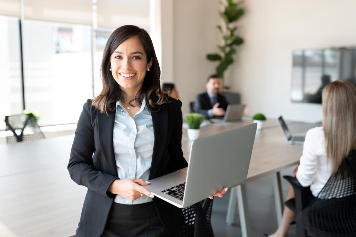 Professional woman holding a laptop in an office, representing career growth in Oklahoma, job search support, and professional recruiting opportunities.