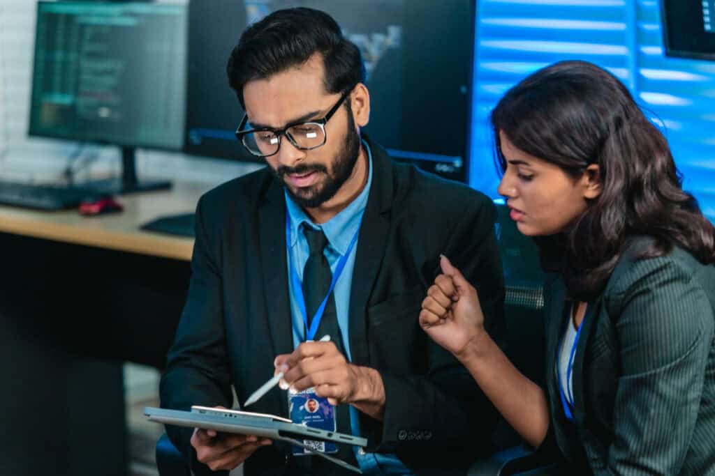 IT professionals discussing technical work, representing an IT staffing agency and IT recruiters helping candidates find IT jobs in Oklahoma.