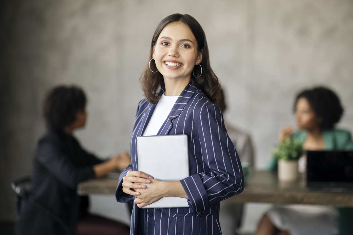Professional woman holding a tablet in a modern office, representing how to find a job in Oklahoma with local career support.