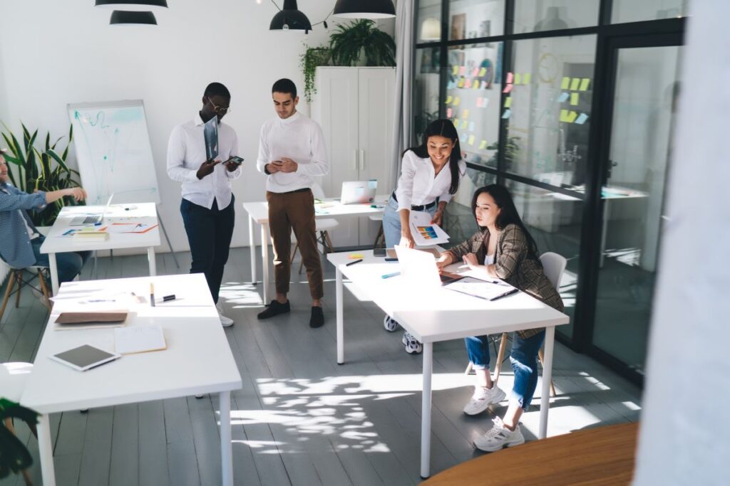 Team collaborating in a modern office environment guided by an employment agency and staffing experts while they create a resume and improve job interview prep through expert staffing