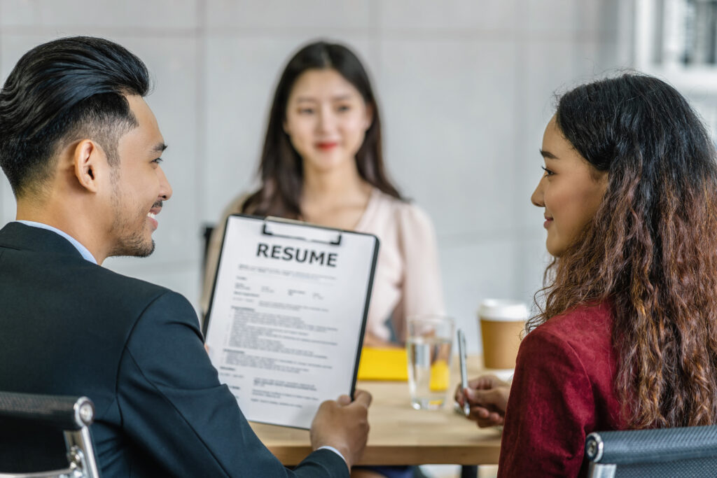 Staffing experts reviewing a candidate resume during job interview prep to help job seekers create a resume that stands out